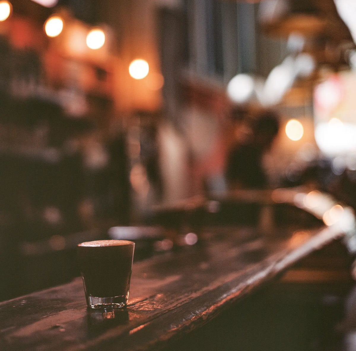 Shot glass with dark beverage and foam for Building Trust in the Uniform Industry online portal