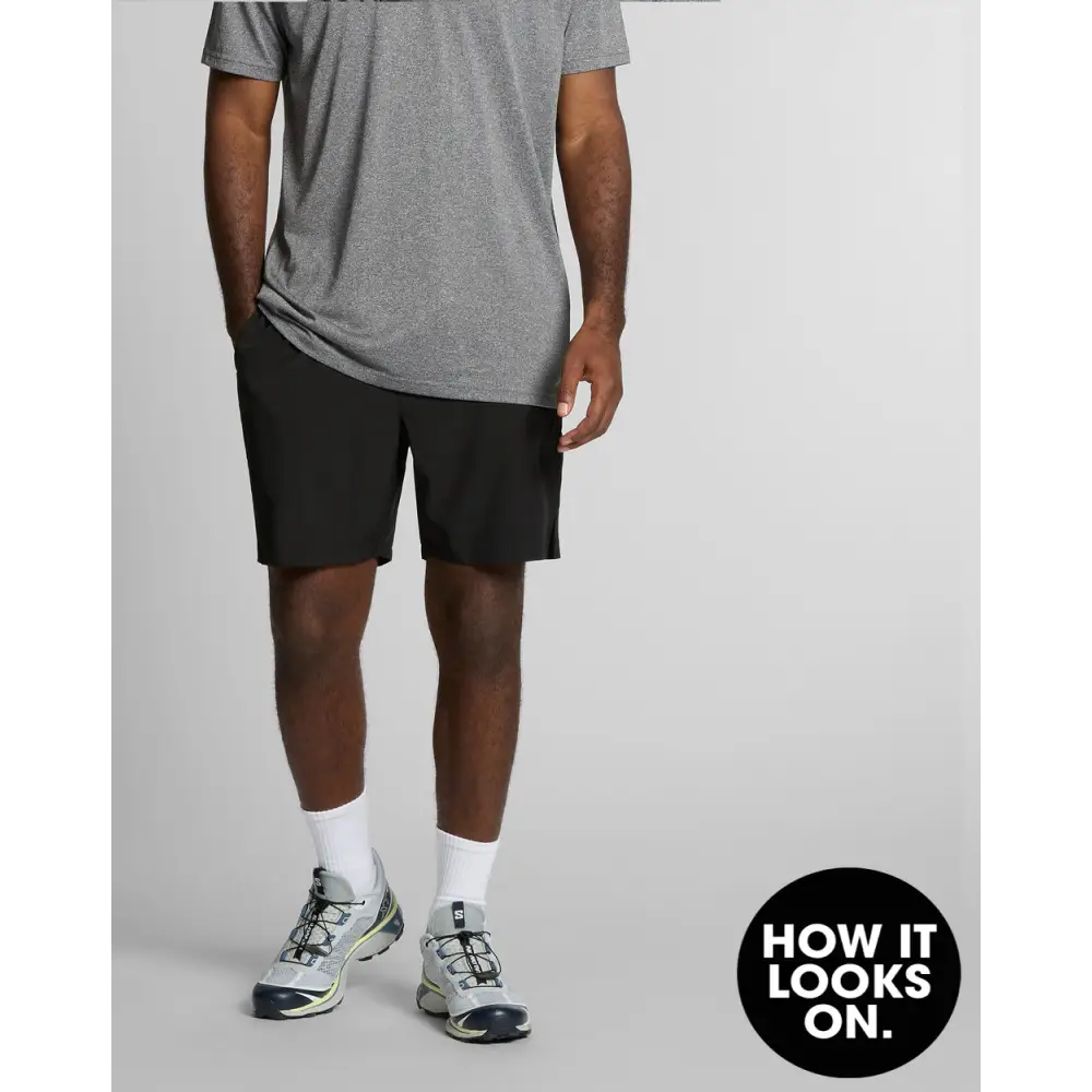 Man wearing gray shirt and black shorts.