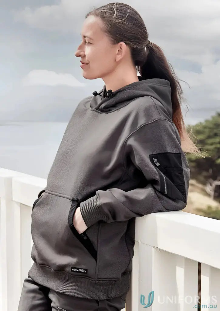 Woman in dark gray water resistant hoodie with black accents and pockets, soft fleece