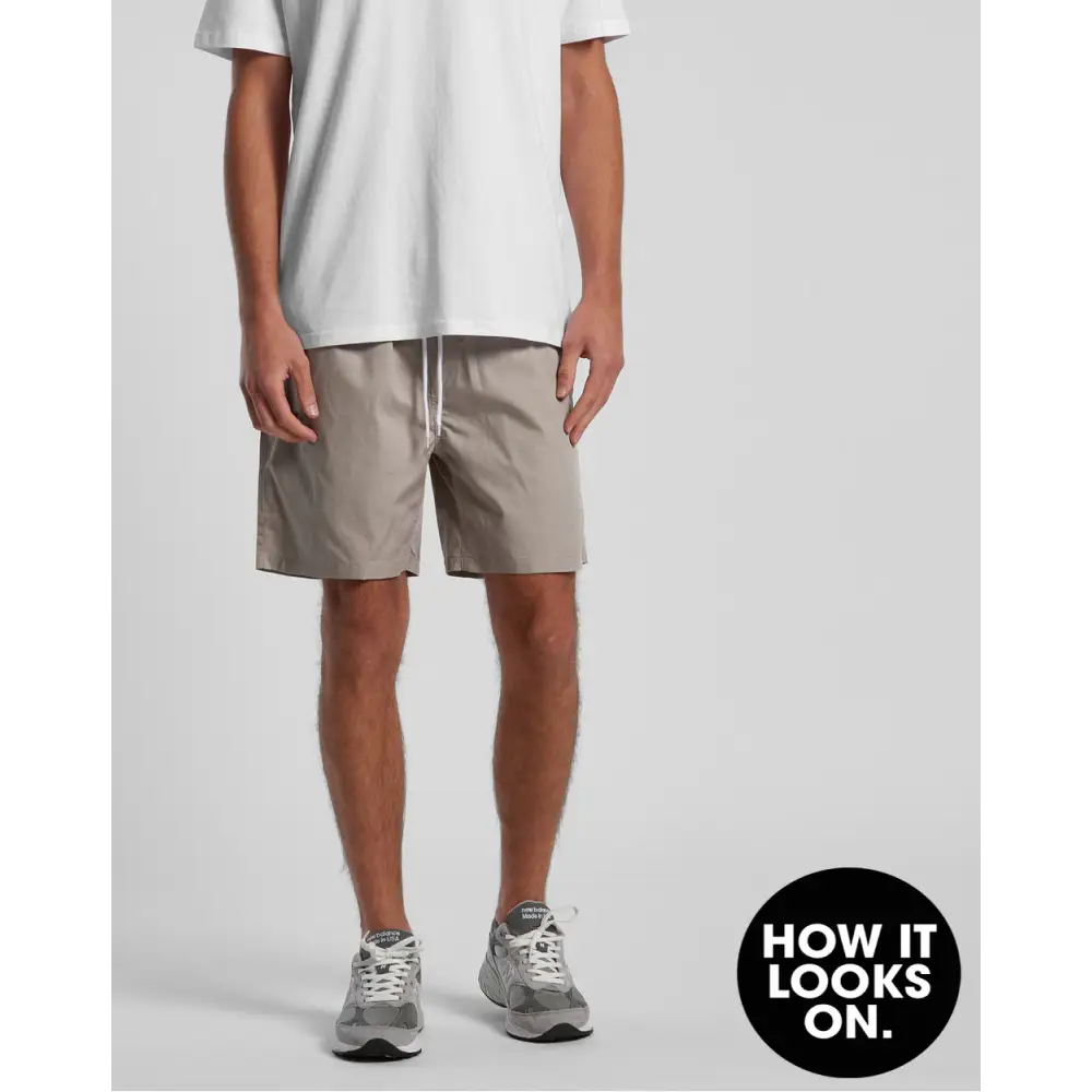 Man wearing khaki shorts and gray sneakers.