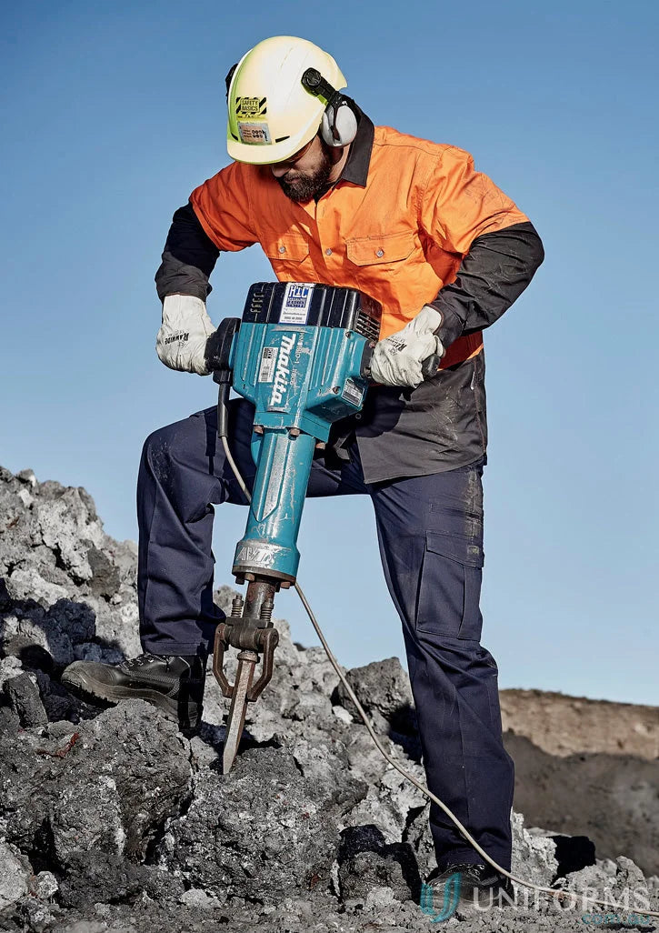 Man using teal jackhammer in Syzmik Mens Cargo Pants ZP501 with reinforced stress points