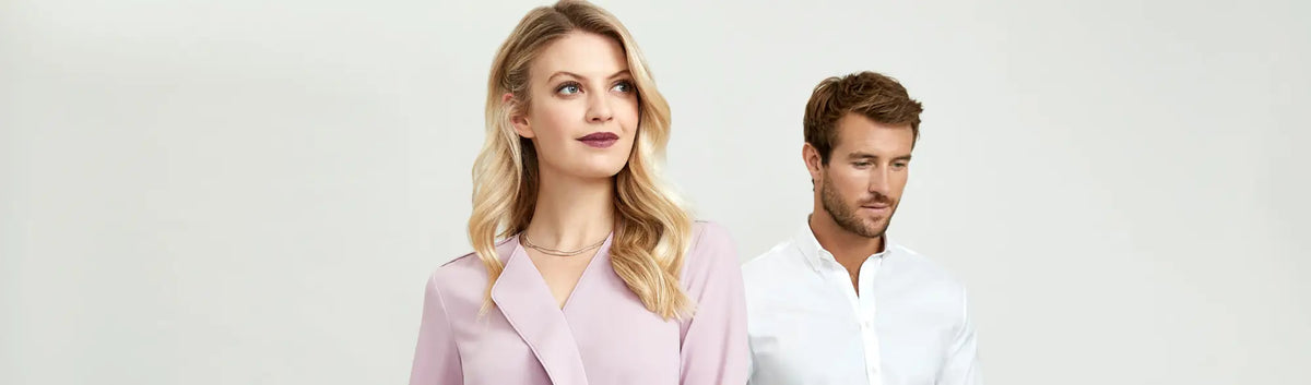 Blonde woman and brown-haired man smiling, showcasing automated uniform ordering for staff uniforms in multi-location businesses