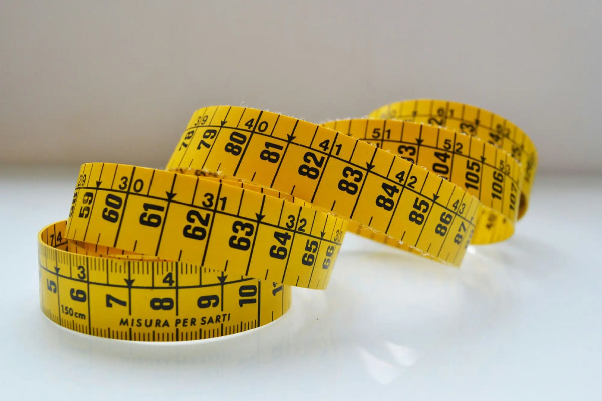 Yellow measuring tape with black markings for chest measurement and half chest measurement