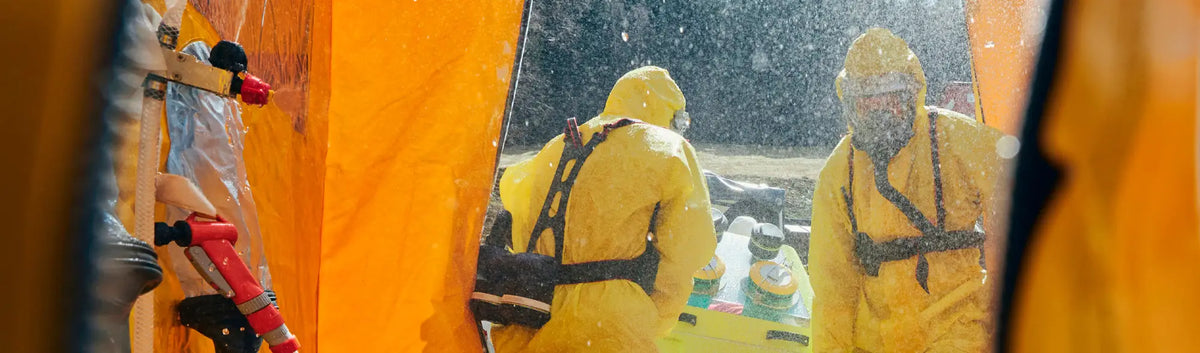 Hazmat-suited personnel using portable eye wash station from PPE Portable Eye Wash Units