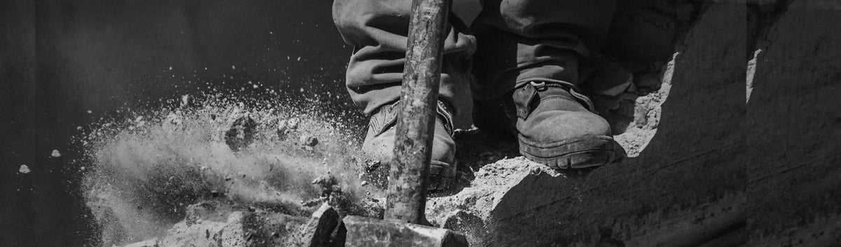 Construction worker using jackhammer in waterproof footwear from PPE Gumboots collection
