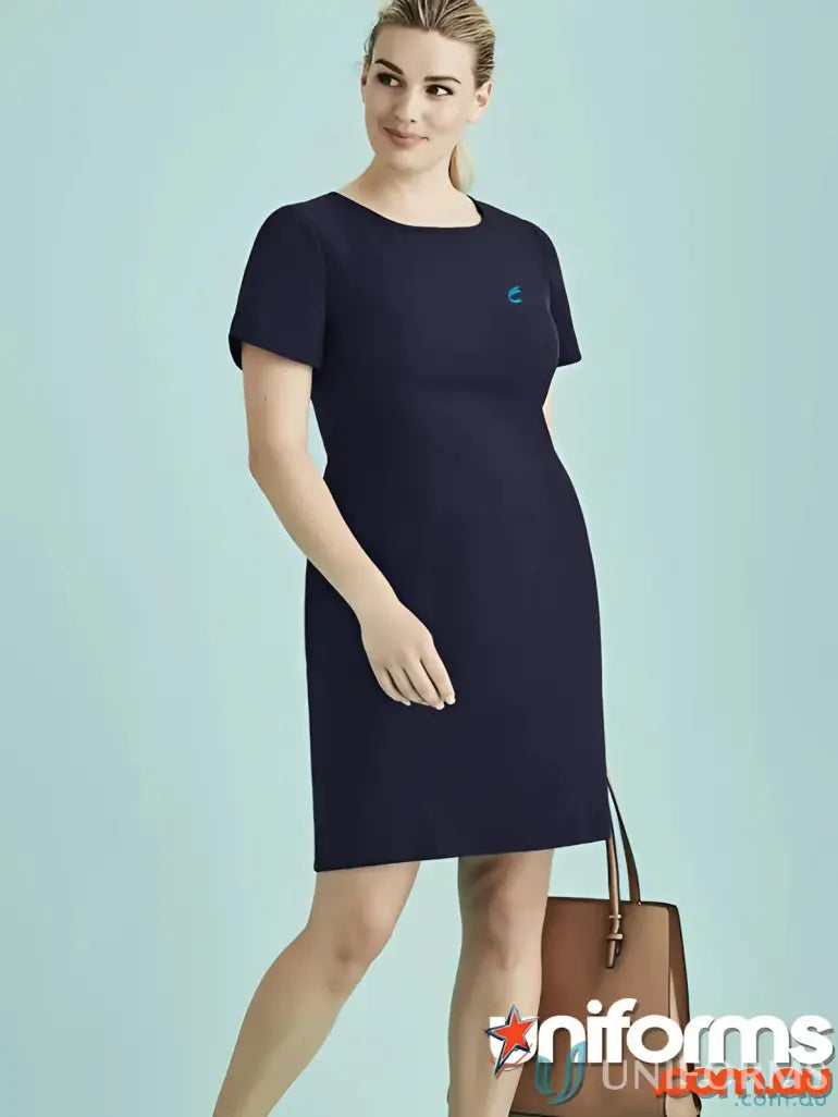 Woman in navy blue IOP EMB Ladies Shift Dress with stretch lining and tan handbag