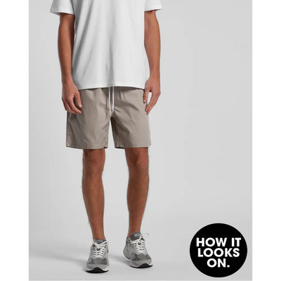 Man wearing khaki shorts and gray sneakers.