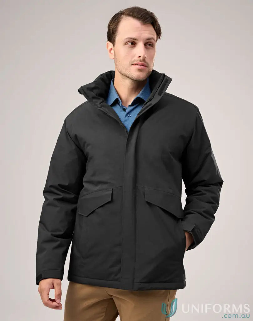 Man wearing waterproof quilted jacket with high collar over blue shirt and brown pants